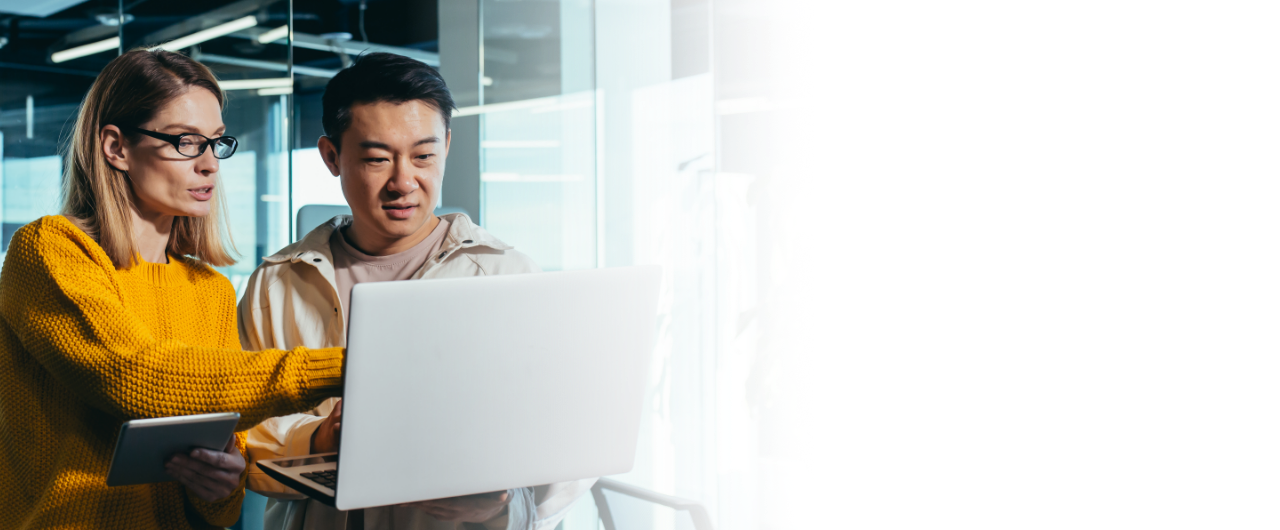 A man and woman reviewing content on a laptop